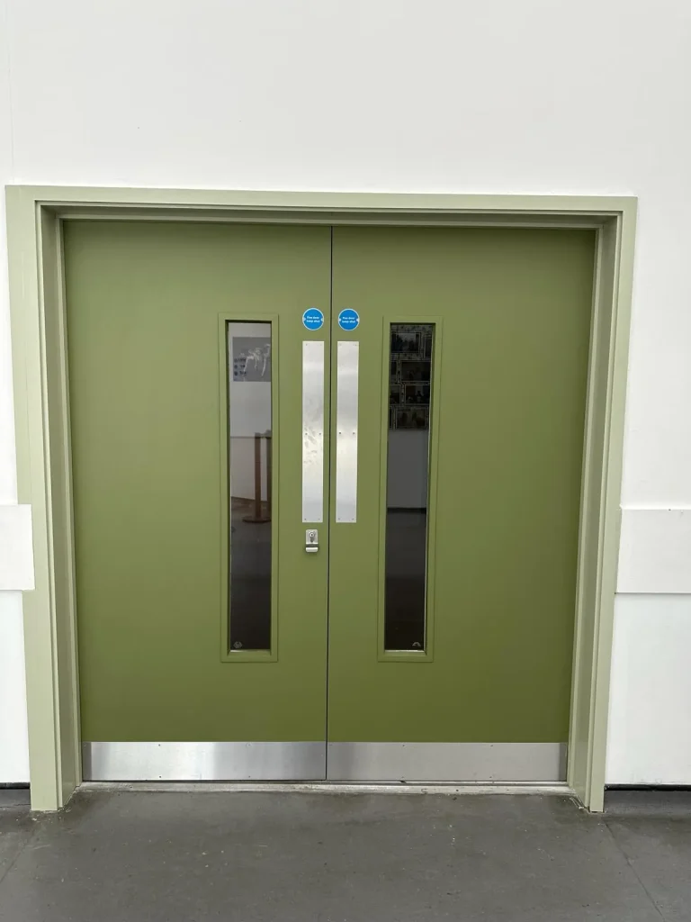 Green painted double doors with vision panels