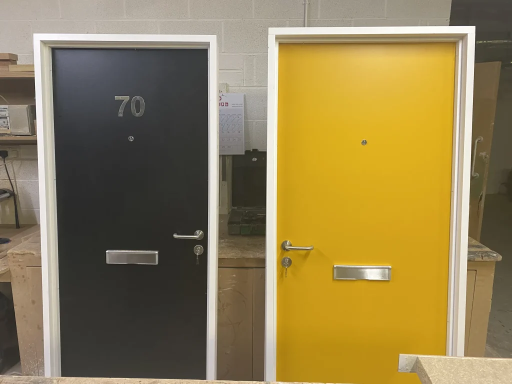 Grey and yellow front entrance doors with letter plates