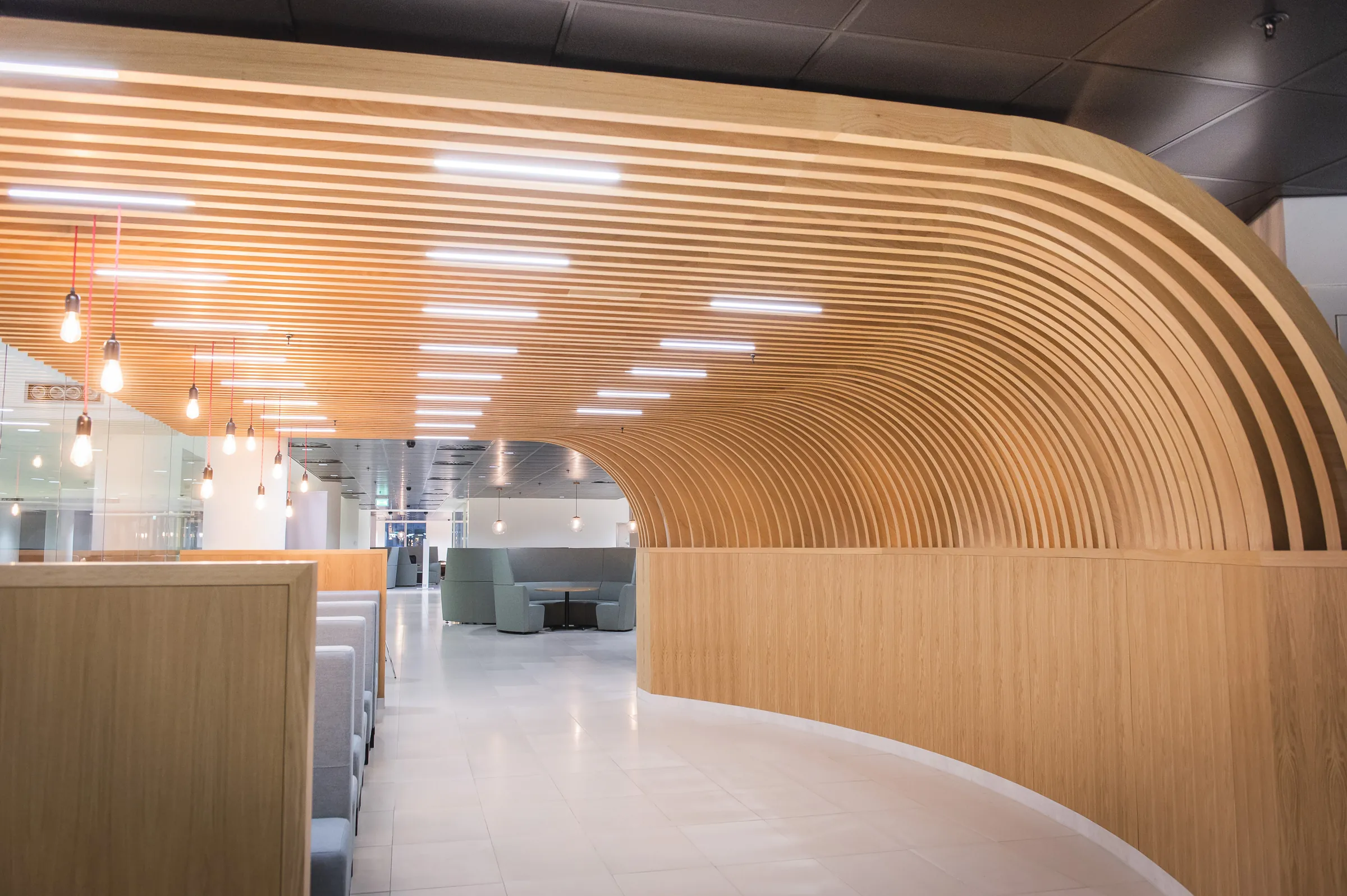 Sweeping slatted oak arch forming a curved walkway