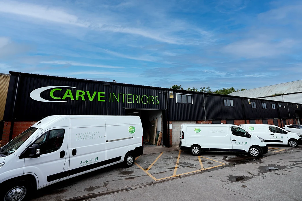 Carve Interiors workshop unit in Staffordshire with branded signage and white company vans parked outside