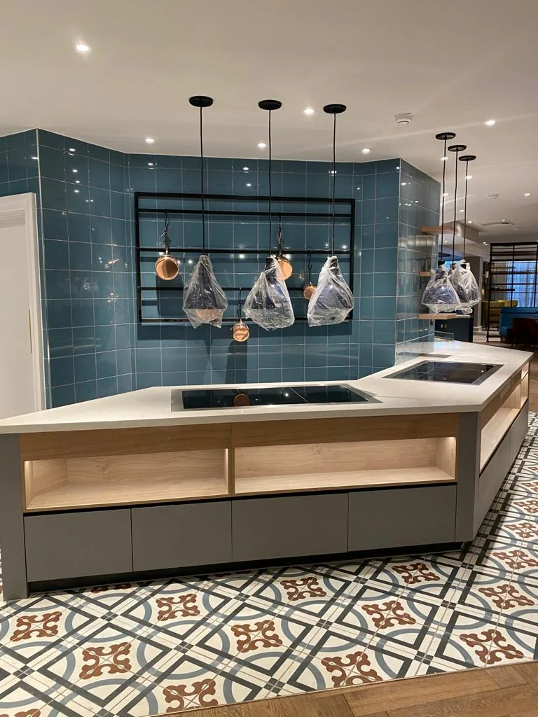 Breakfast servery island with pale timber shelving under pendant lights