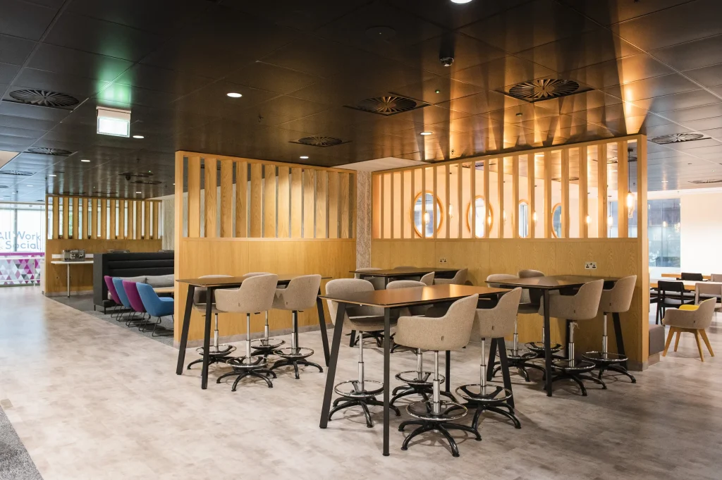 Oak arch and booth seating next to a café area with white tables