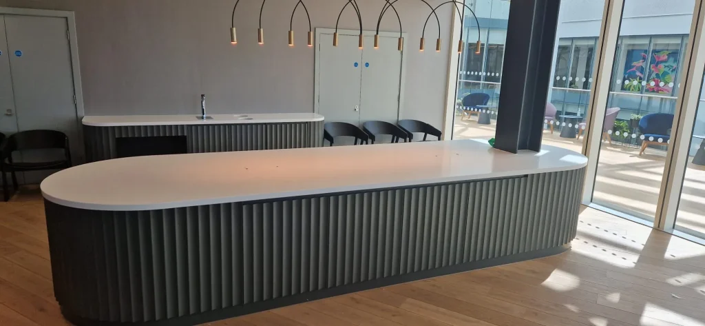 Long island with a white solid surface top and grey fluted front