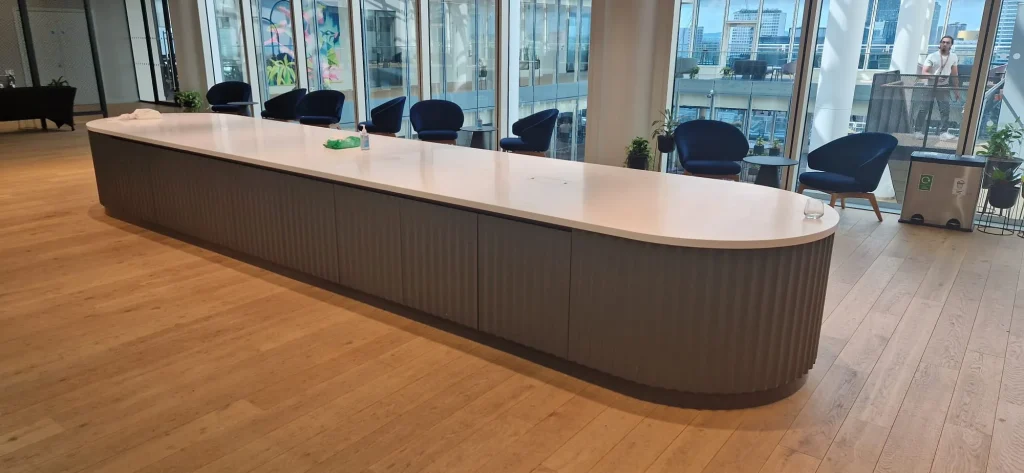 Long solid surface counter with a fluted front in a bright open-plan space