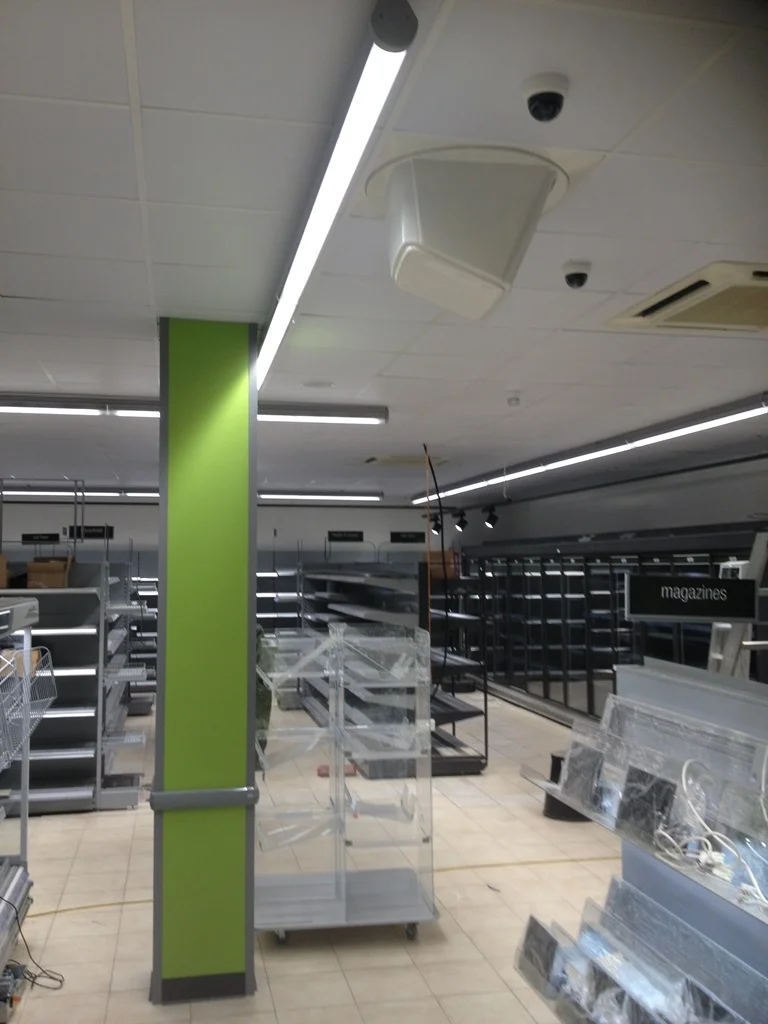 Lime green column and new shop shelving ahead of stocking at Co-op Prestbury
