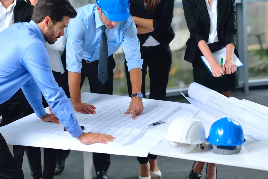 Project team reviewing construction drawings around a table
