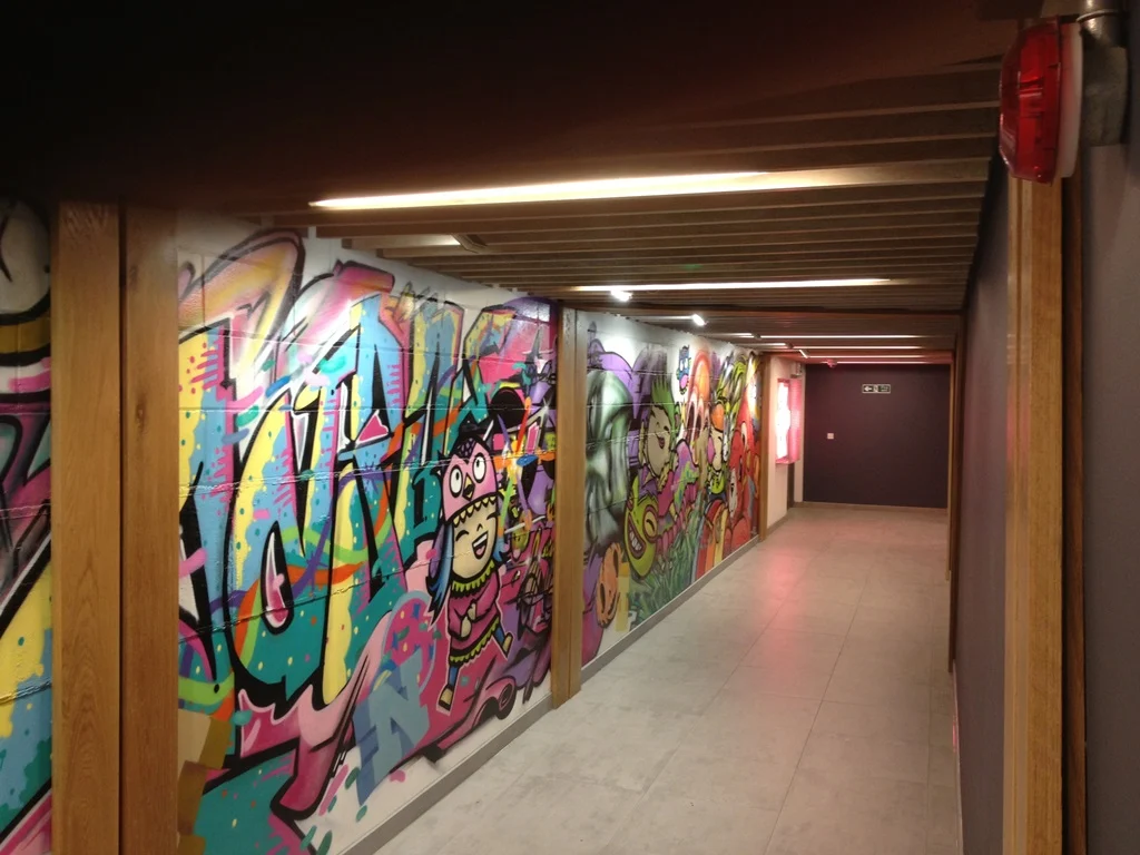 Graffiti mural corridor with oak-framed panels and timber slatted ceiling at Leeds Trinity Shopping Centre