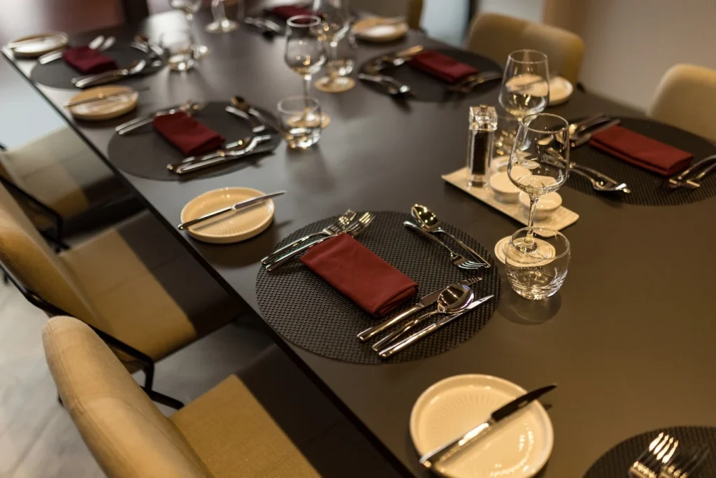 Table laid with burgundy napkins, glassware and cutlery in a Premier League football club dining room