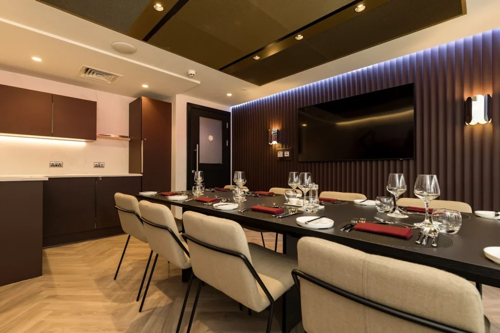Premier League football club private dining room with laid table, fluted wall panelling and blue LED lighting